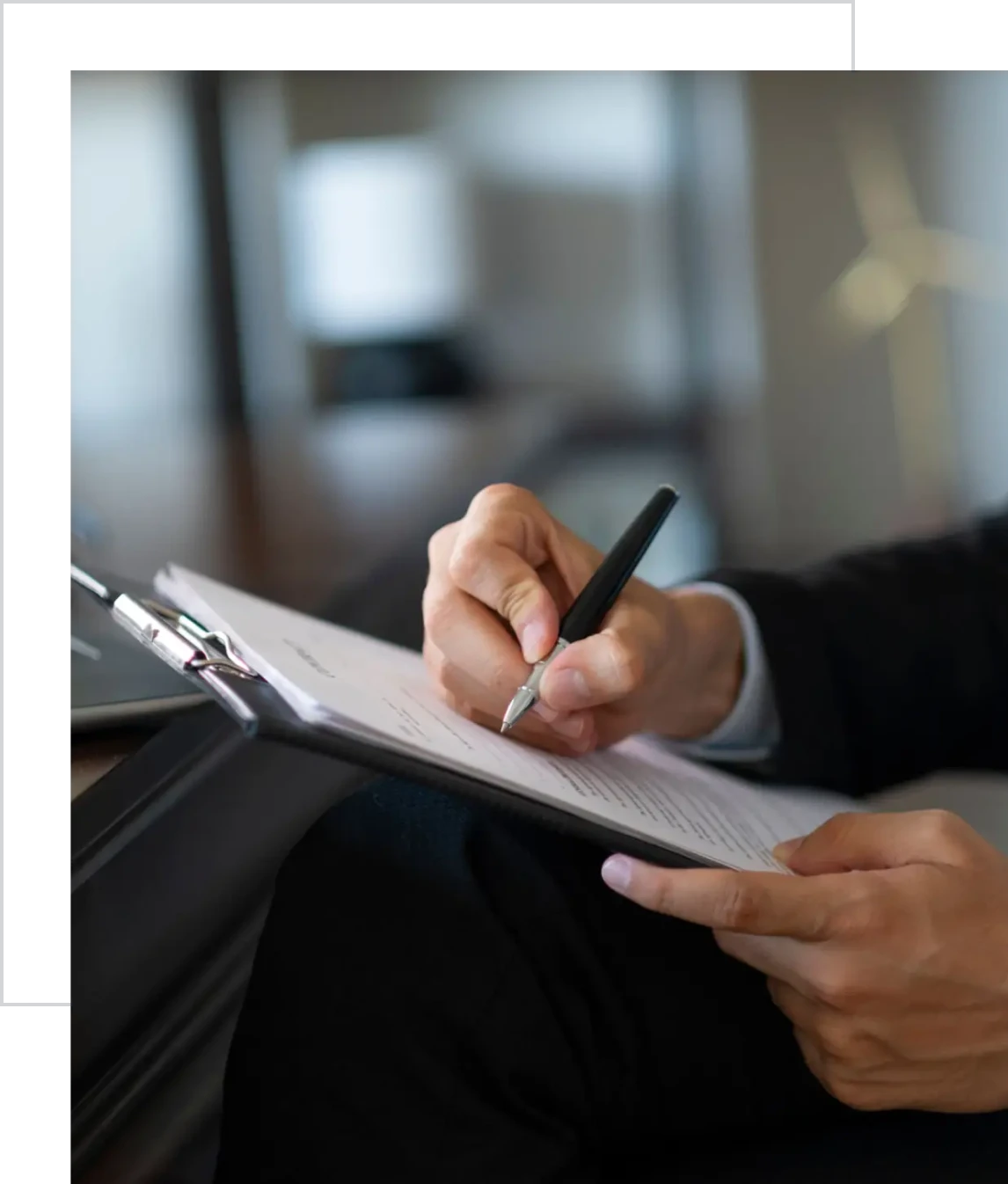 Hand holding pen over documents